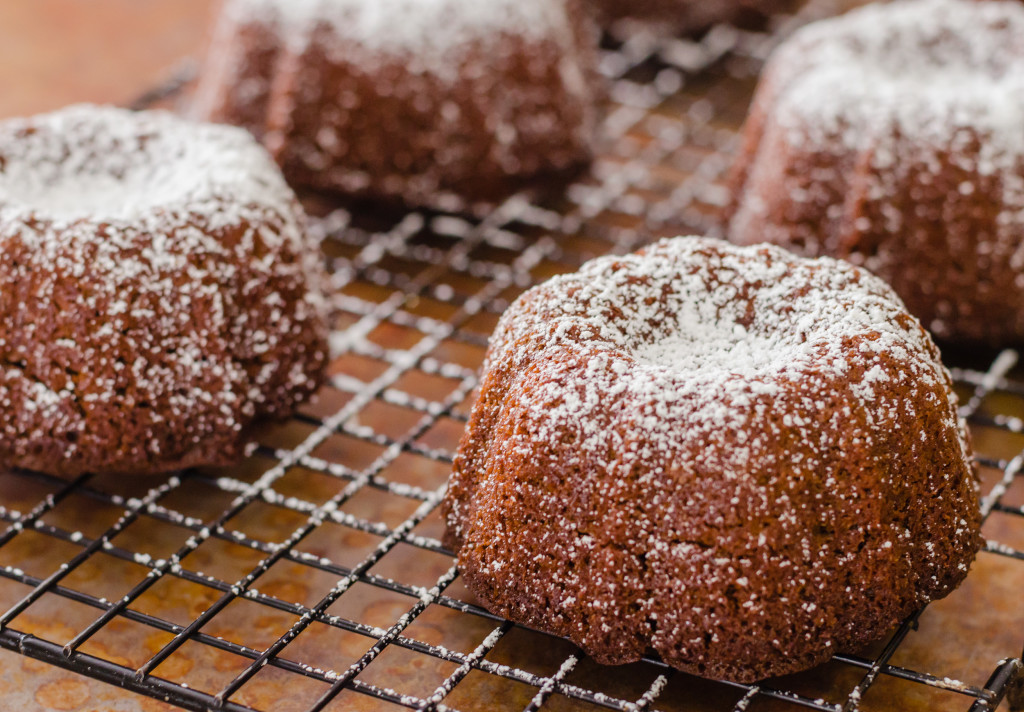 Mini vegan chocolate cakes cooling on the rack and dusted with sugar