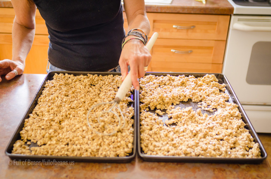 Spreading the granola on cookies sheets for cooking