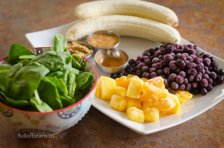 The essential ingredients: fresh baby spinach, bananas, frozen blueberries and mango, cinnamon, flax, and coconut sugar.