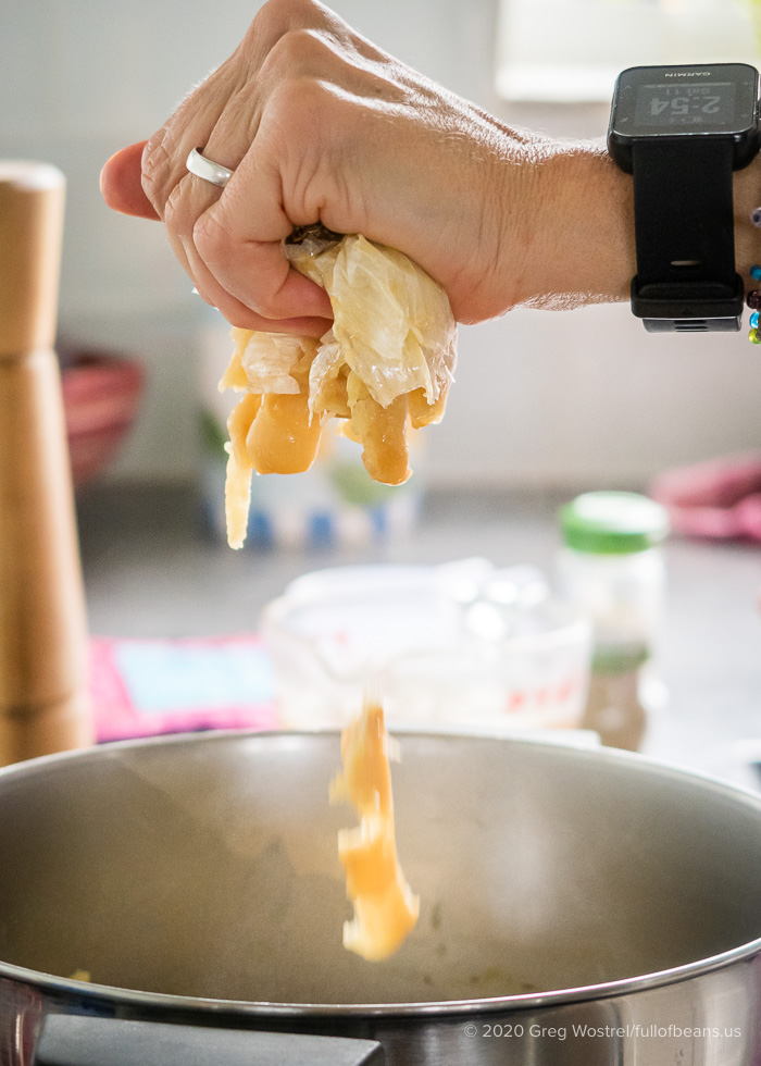 squeezing roasted garlic into a pot of mashed potatoes