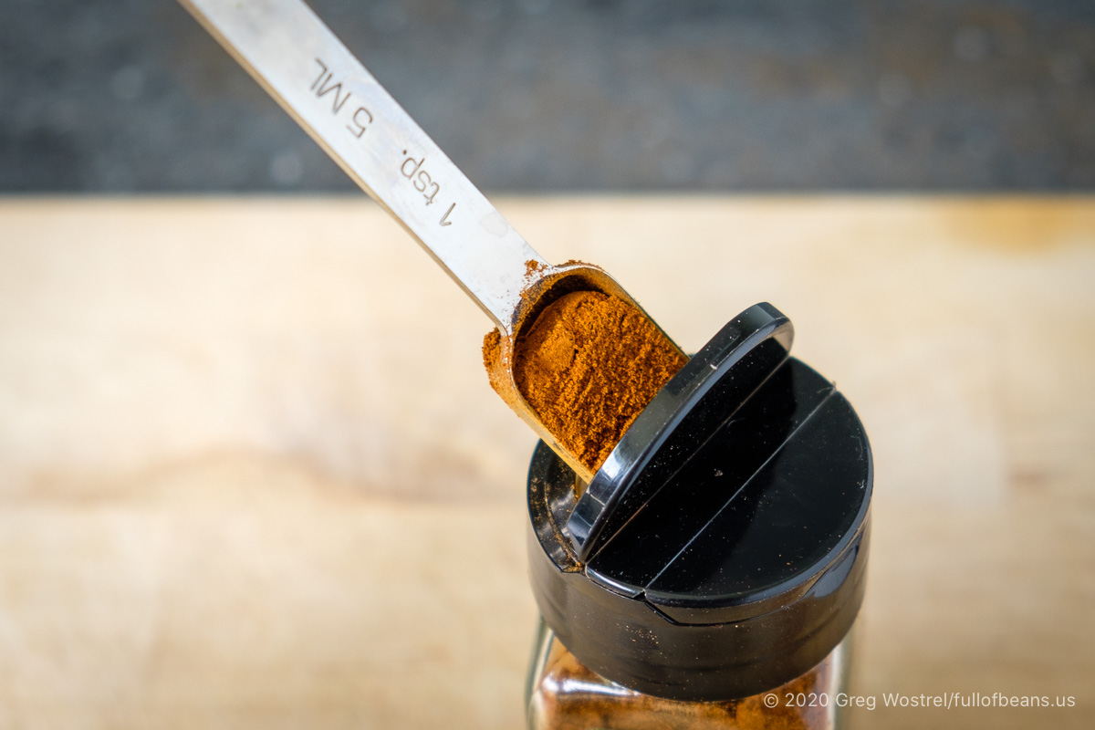 rectangular measuring spoon inserted in small spice jar top
